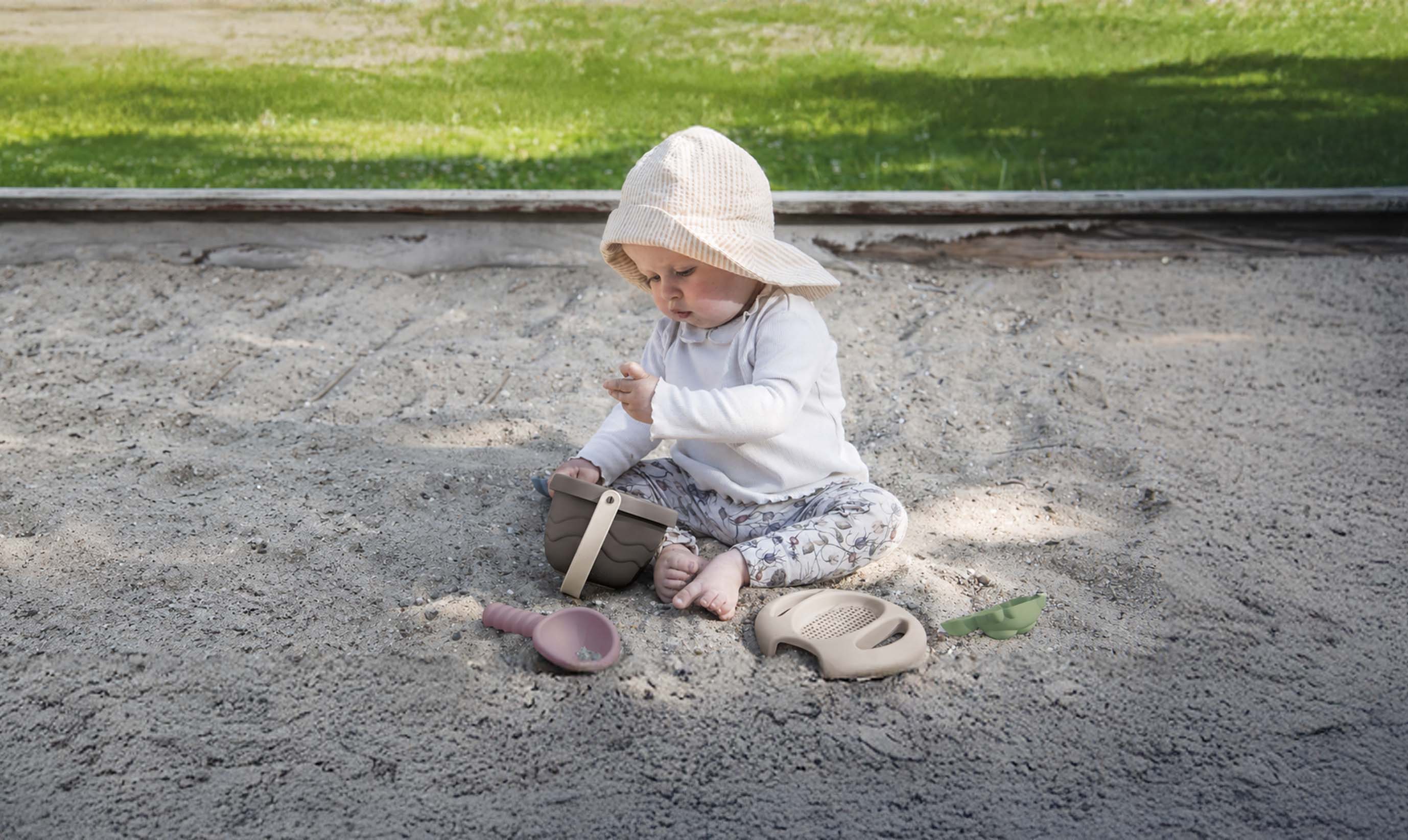 Enfant dans un bac à sable avec des jouets